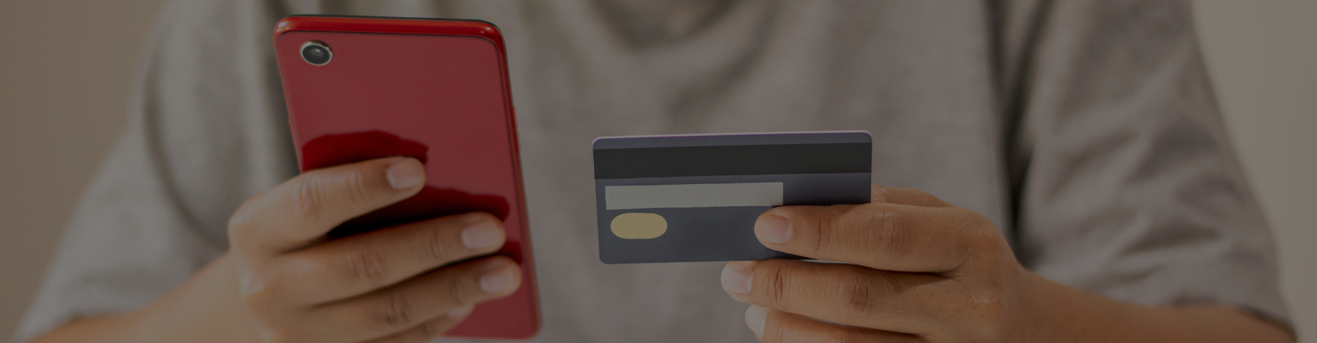 Individual holding phone and credit card banner